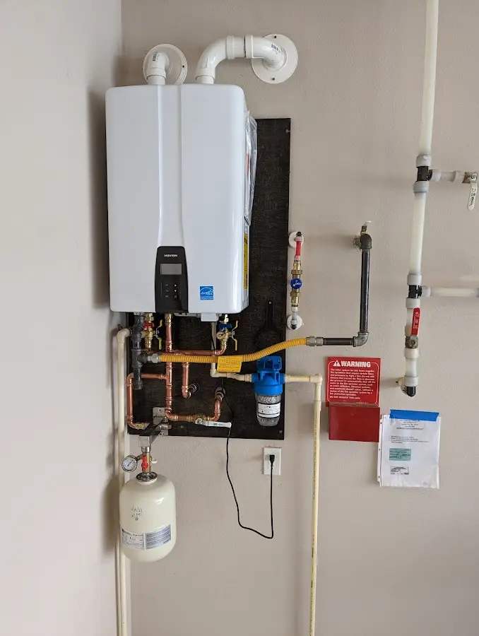 Professional plumber installing copper piping in a Mason City home